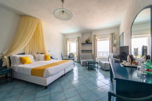 a bedroom with a bed and a living room at Borgo Romantica - Resort & Spa in Sant'Angelo D'Ischia