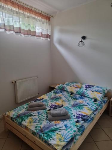 uma cama com almofadas num quarto em Apartament Kosynka 