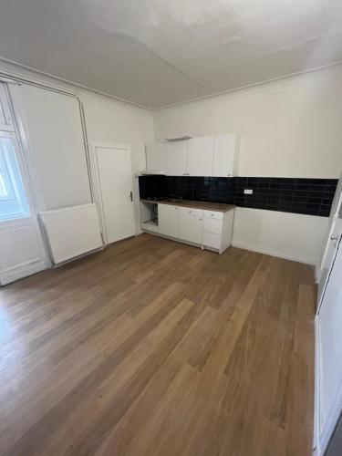 een lege kamer met witte kasten en een houten vloer bij Bkenkember Apart in Antwerpen