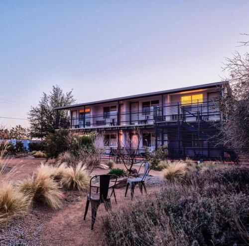 a building with two chairs in front of it at Thunderbird Hotel in Marfa