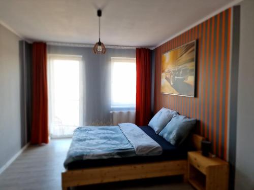 - une chambre avec un lit et 2 fenêtres dans l'établissement WRN APARTAMENTY, à Kalisz