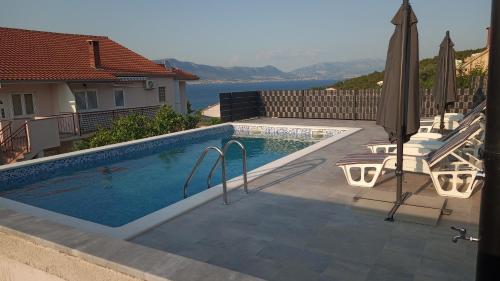 een zwembad met uitzicht op het water bij Apartmani Gaby in Trogir