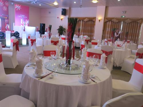 a dining room with white tables and white chairs at Sai Gon Kim Lien Hotel Vinh City in Vinh