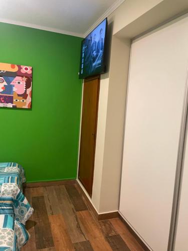 a room with a green wall and a flat screen tv at Manolo in Santa Rosa
