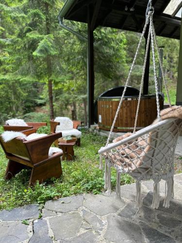 a swing in a yard with chairs and a grill at Chalet Látky in Látky