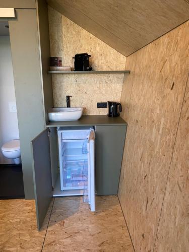 a small refrigerator in a kitchen with a counter at Natuurhuisjes Lust en Last in Sommelsdijk