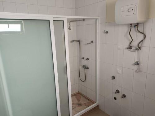 a bathroom with a shower with a glass door at Casa Joãozinho De Lora in São Filipe