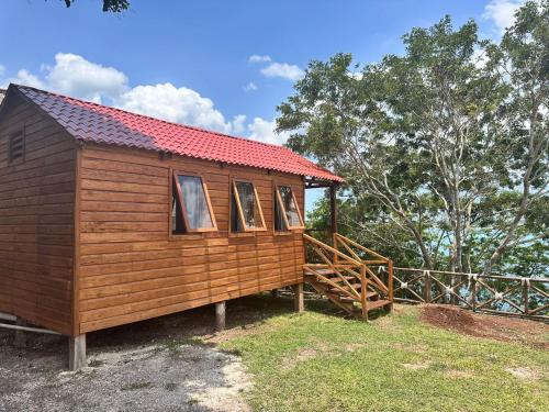 a wooden cabin with a red roof at bacalar My Love Front Laguna in Bacalar