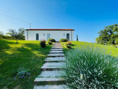a house on a hill with a pathway leading to it at Ritorno alla Natura in Recanati