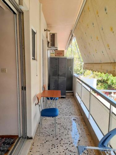 a room with a chair and a refrigerator on a balcony at Condo in Kalamata - Park View in Kalamata