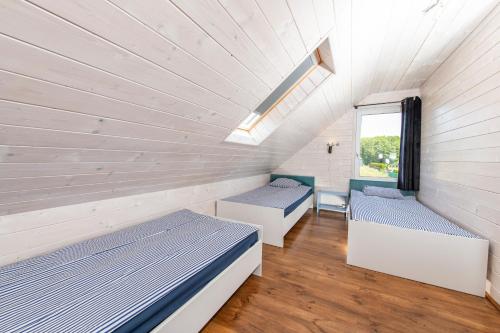Zimmer mit 2 Betten und einem Fenster in der Unterkunft Domki przy Mysliwskiej in Grzybowo