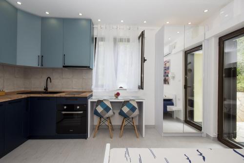 a kitchen with blue cabinets and a sink at Studio Apartments Summer Time in Kamenari
