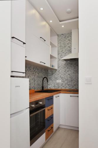 a kitchen with white cabinets and a sink at Studio Apartments Summer Time in Kamenari