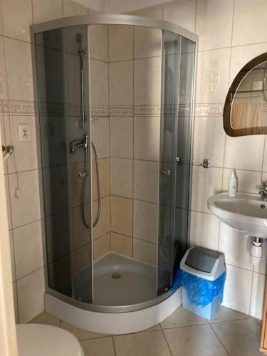 a shower with a glass door in a bathroom at Apartament Turkus in Gdynia