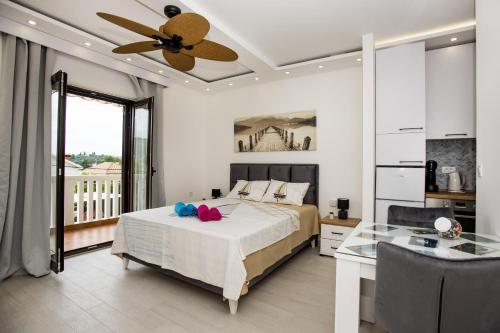 a bedroom with a bed and a ceiling fan at Studio Apartments Summer Time in Kamenari