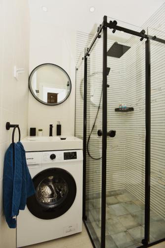 a washing machine in a bathroom with a shower at Studio Apartments Summer Time in Kamenari