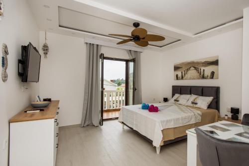 a bedroom with a bed and a ceiling fan at Studio Apartments Summer Time in Kamenari