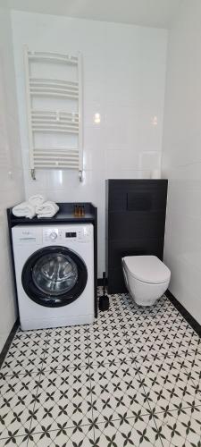 y baño con lavadora y aseo. en Mazovia Gold Apartament 101, en Płock