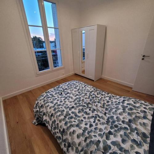 une chambre avec un lit dans une pièce avec des fenêtres dans l'établissement BLUMENTHAL, à Épinay-sur-Seine