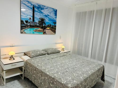 um quarto com uma cama e duas mesas de cabeceira com candeeiros em CURA MARINA 2- Apartment BY THE BEACH em Playa del Cura
