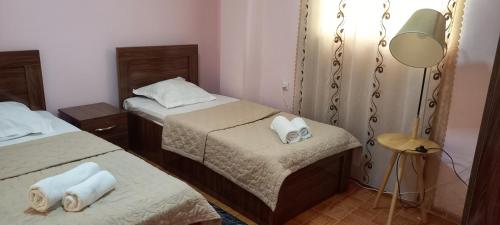 a small room with two beds and a lamp at Guest House LIBU Zugdidi in Zugdidi