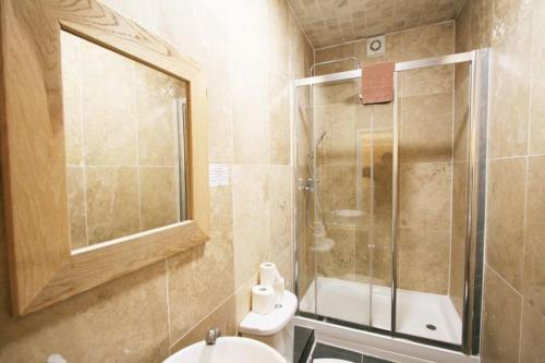 een badkamer met een douche, een toilet en een wastafel bij Central Studios Gloucester Place by Roomsbooked in Cheltenham