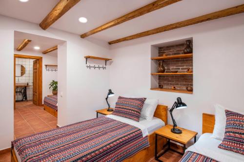 Duas camas num quarto com paredes brancas e tectos em madeira em Your home, Lagodekhi em Lagodekhi