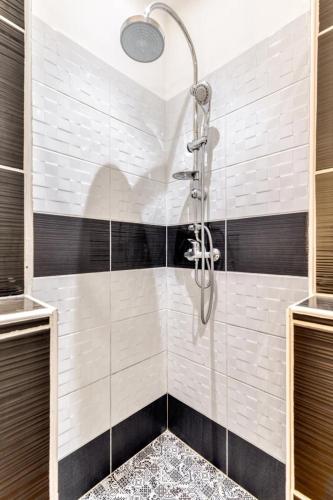 une douche avec une porte vitrée dans une salle de bain dans l'établissement Soleil Sucré T2 Centre historique de Narbonne, à Narbonne