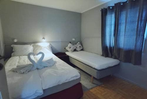 a bedroom with two beds with swans decorations on them at Banpim apartment with Jacusszi in Gravdal