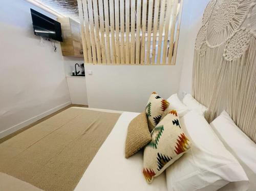 Un dormitorio con una cama blanca con almohadas. en Estudio Albufera, en Valencia