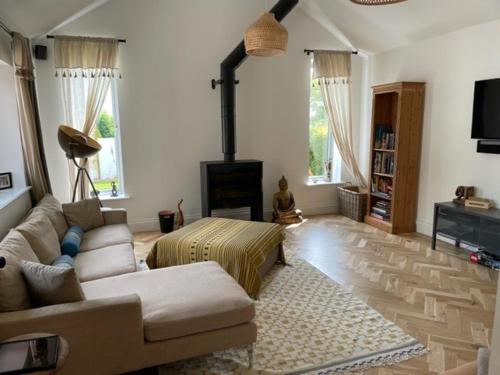 a living room with a couch and a fireplace at Luxury Devon House in Chulmleigh