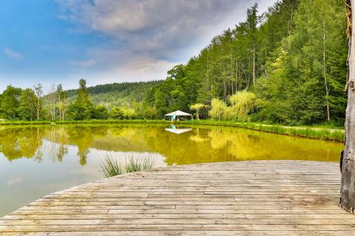 a dock with a gazebo in the middle of a lake at Tinyhouses - Domain "La vallée des Prés" in Bande