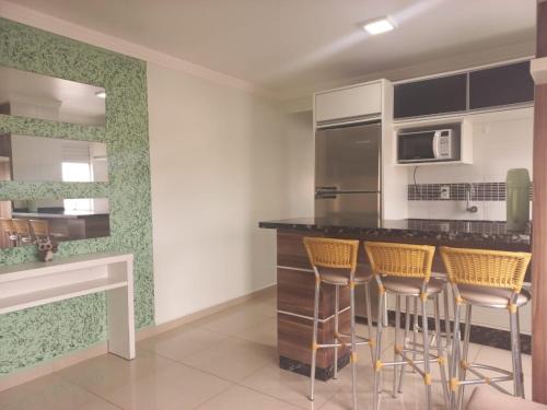 a kitchen with a counter and stools in a room at Residencial Nicole in Florianópolis