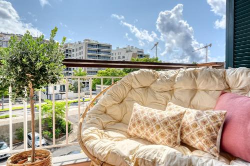 a couch on a balcony with a view of a city at Monumental Tower, a Home in Madeira in Funchal