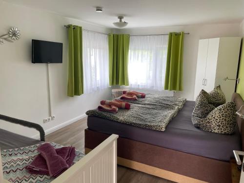 sypialnia z zielonymi zasłonami i łóżkiem z butami w obiekcie Ferienwohnung Fiene w mieście Groß Zicker