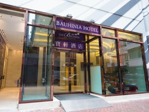 a building with a sign for a hotel at The Bauhinia Hotel - Tsim Sha Tsui in Hong Kong
