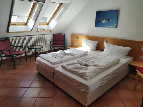 1 dormitorio con 2 camas, sillas y ventanas en Apartment Seeadler, en Dewichow