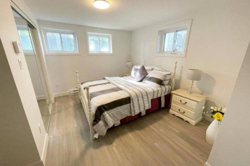 a small bedroom with a bed and a night stand at Stylish and luxurious apartment basement unit in Longueuil