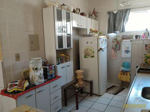uma cozinha com armários brancos e um frigorífico em Icaraí Atlantic Village em Caucaia