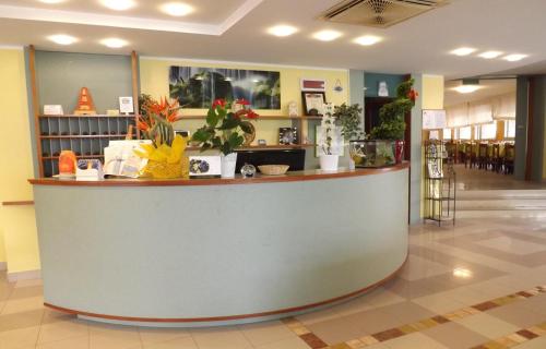 a lobby with a counter with plants on it at Hotel Villa Claudia in Bellaria-Igea Marina