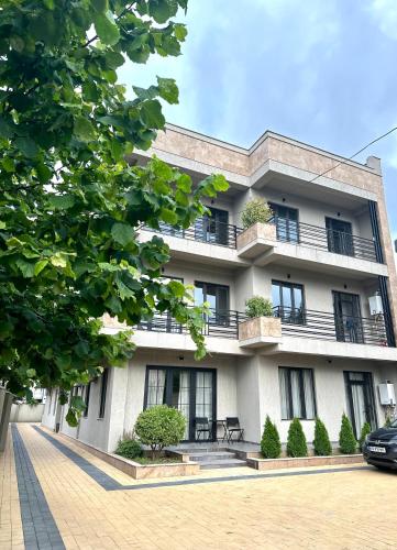een wit gebouw met balkons en planten erop bij Aparthotel Kutaisi in Koetaisi