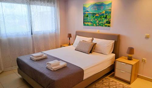 a bedroom with a bed with two towels on it at Nafplio, hill with an amazing view in Nafplio