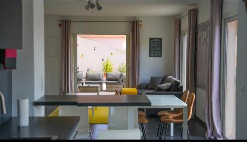 uma cozinha e sala de estar com mesa e cadeiras em Chez Pasqua ! Appartement spacieux avec terrasse 2 chambres 6 couchages en Rooftop em LʼÎle-Rousse