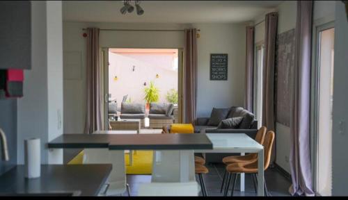 une cuisine et un salon avec une table et des chaises dans l'établissement Chez Pasqua ! Appartement spacieux avec terrasse 2 chambres 6 couchages en Rooftop, à LʼÎle-Rousse