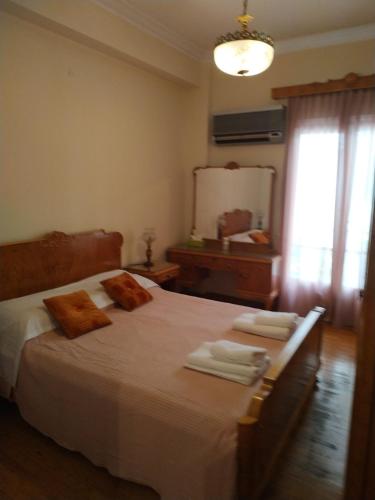 アテネにあるNicole Apartmentのベッドルーム1室(大型ベッド1台、タオル付)