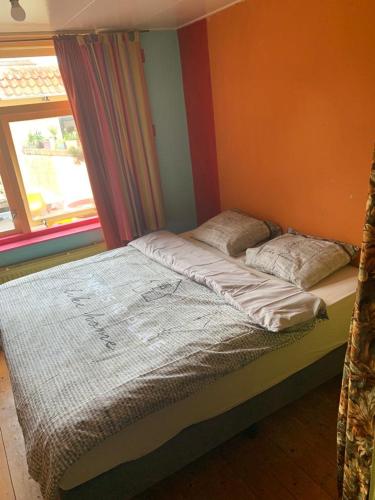 ein Bett in einem Schlafzimmer neben einem Fenster in der Unterkunft An Artist Created it in Middelburg