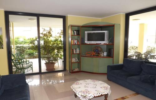 a living room with two couches and a tv at Hotel Villa Claudia in Bellaria-Igea Marina