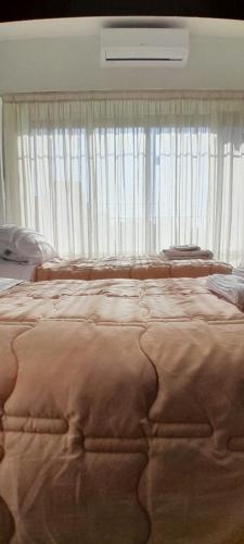 um quarto com uma cama grande e uma janela grande em Súper Luminoso en Caballito em Buenos Aires