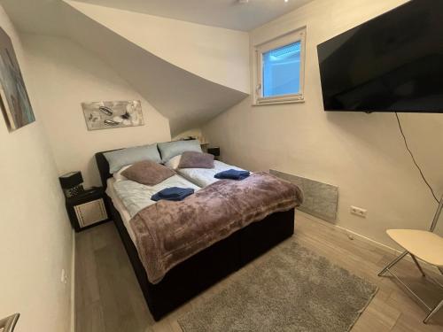 a bedroom with a bed and a flat screen tv at Ferienwohnung am Seeblick in Feldkirchen in Kärnten
