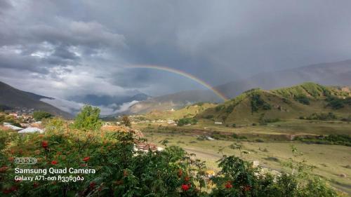 a rainbow in the sky over a valley at M7 House in Gorists'ikhe